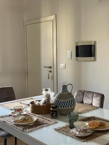 einem Esstisch mit Tellern und einer Vase darauf in der Unterkunft Casa di charme "Al Moro Avola " in Avola