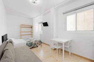 a living room with a couch and a table and a bed at Apartamentos Calle Nueva in Málaga