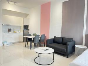 sala de estar con sofá, mesas y cocina en Chambers Residence by Gloria Homes, en Kuala Lumpur