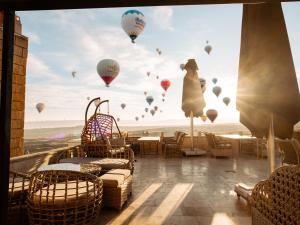a balcony with hot air balloons in the sky at Cappadocia Pegasos Cave Suite Hotel in Uçhisar +113 photos