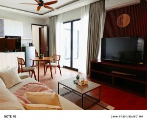 a living room with a couch and a flat screen tv at Apartment De Palm in Uluwatu