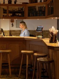 una mujer sentada en un bar con un portátil en Gasthof Engel, en Müllheim