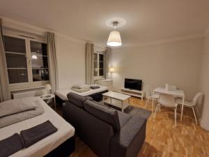ein Wohnzimmer mit Sofa und Fernseher in der Unterkunft Home Inn RSG19 in Stockholm