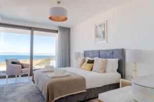 una camera da letto con un letto e vista sull'oceano di Peralta Beach - Stunning Villa with Private Pool 03 a Lourinhã Altre 41 foto