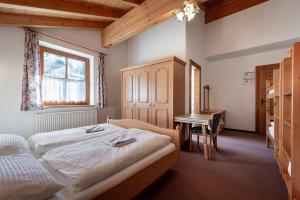 a bedroom with two beds and a desk in it at Hecherhaus in Schwaz