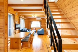 eine Treppe in einem Blockhaus mit einem Tisch und Stühlen in der Unterkunft Setoke TSUDA - Vacation STAY 53164v in Tsuruwa