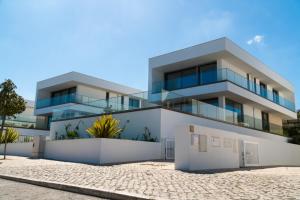 un edificio bianco con molte finestre di Peralta Beach - Stunning Villa with Private Pool 03 a Lourinhã