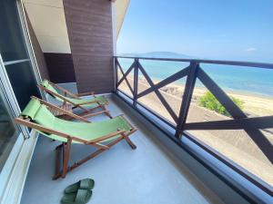 2 Stühle auf einem Balkon mit Blick auf den Strand in der Unterkunft Setoke TSUDA - Vacation STAY 53164v in Tsuruwa