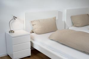 - une chambre blanche avec un lit et une table de chevet dans l'établissement Kara Ben Nemsi, à Ilmmünster 11 autres photos