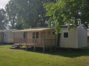 a tiny house with a porch and a deck at ZEcamping 4 étoiles dog friendly bar piscine couverte in Faverolles-sur-Cher