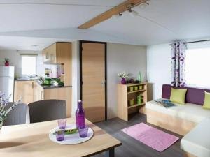a living room with a table and a couch at ZEcamping 4 étoiles dog friendly bar piscine couverte in Faverolles-sur-Cher