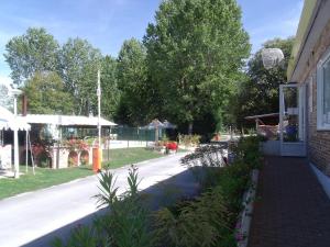 a street with a building and a garden with flowers at ZEcamping 4 étoiles dog friendly bar piscine couverte in Faverolles-sur-Cher