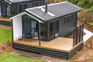 a tiny house with a deck and a patio at Lemon Myrtle Villa in Valdora