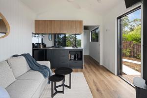 a living room with a couch and a kitchen at Lemon Myrtle Villa in Valdora
