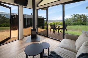a living room with a couch and a balcony with a table at Bottlebrush Villa in Valdora