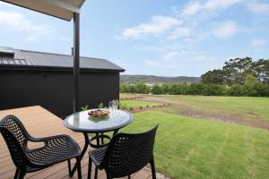a patio with a table and chairs on a deck at Bottlebrush Villa in Valdora