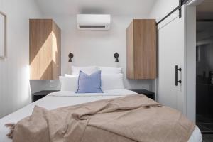 a bedroom with a large bed with a blue pillow at Bottlebrush Villa in Valdora