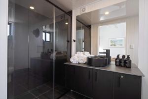 a bathroom with a glass shower and a counter with towels at Bottlebrush Villa in Valdora +17 photos