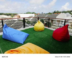 Drei verschiedenfarbige Kissen liegen auf einem Balkon. in der Unterkunft Apartment De Palm in Uluwatu + 1 Foto