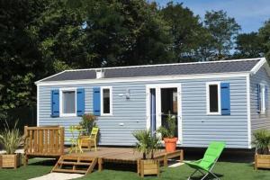 a blue tiny house with a porch and a deck at Camping 3 étoiles - Piscine - ccbafeb in Avrillé