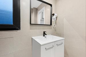 a bathroom with a white sink and a mirror at Apartamentos Calle Nueva in Málaga +45 photos