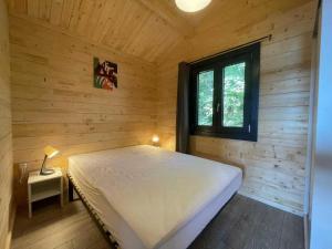 a bedroom with a bed in a wooden cabin at ZEcamping 2 étoiles animaux acceptés snack-bar et vue lac in Neffes