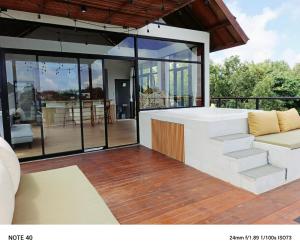 ein Wohnzimmer mit einer Couch und etwas Glas in der Unterkunft Apartment De Palm in Uluwatu