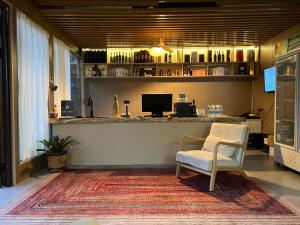 a waiting room with a chair and a bar at Turpan Grape Spring Inn in Turfan