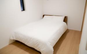 uma cama branca num canto de um quarto em 福岡旅路 博多住吉包棟民宿 3號館 em Fukuoka