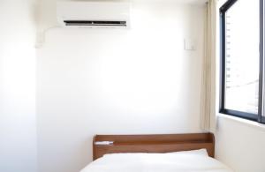 um quarto com uma cama e uma janela em 福岡旅路 博多住吉包棟民宿 3號館 em Fukuoka mais 14 fotografias