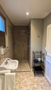 une salle de bain avec une baignoire, une douche et un lavabo dans l'établissement BonBon Chambre d'hôtes, à Saint-Julien-de-Lampon