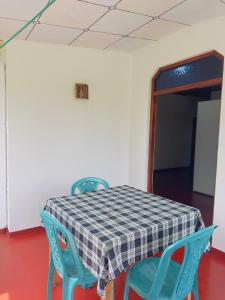 a table with two blue chairs and a checkered at Goyambokka Richard Home Stay in Tangalle +12 photos