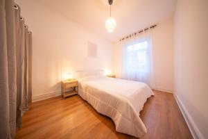 um quarto branco com uma cama e uma janela em appartement confortable à la frontière de bâle One 6 personnes em Saint-Louis mais 1 fotografia