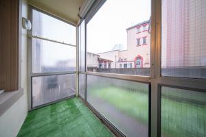 uma sala vazia com janelas e um piso verde em appartement confortable à la frontière de bâle One 6 personnes em Saint-Louis