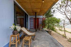 un porche de una casa con sillas y mesa en Xóm Chài Tân An, en Ấp An Lộc A