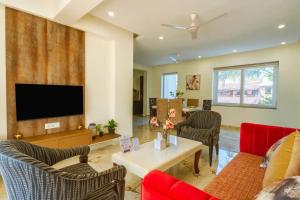 Una sala de estar con un sofá y un televisor en Luxury Apartments Candolim Luxfort, en Candolim