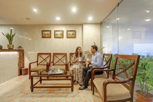 un hombre y una mujer sentados en una habitación en Hotel Continental Inn, en Chennai