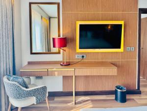 a room with a desk with a television and a chair at InterContinental Lusaka by IHG in Lusaka
