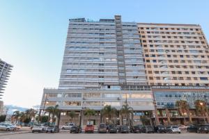 a large building with cars parked in front of it at Ocean View Apartment by Hilton & TGV Station in Tangier