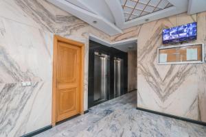 a hallway with a wooden door and marble walls at Ocean View Apartment by Hilton & TGV Station in Tangier