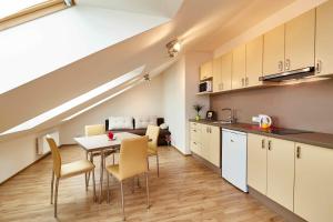 a kitchen and dining room with a table and chairs at Kasablanka apartments in Prague