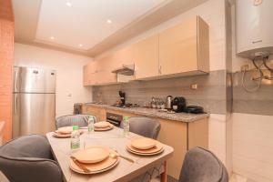 a kitchen with a table and chairs and a refrigerator at Ocean View Apartment by Hilton & TGV Station in Tangier