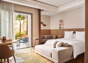 a hotel room with a bed and a couch and a patio at Four Seasons Hotel Rabat at Kasr Al Bahr in Rabat
