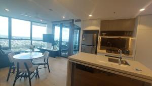 eine Küche und ein Esszimmer mit Tisch und Stühlen in der Unterkunft Luxury Riverfront Apartment level 38 Queen's Wharf Tower in Brisbane