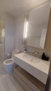 ein Badezimmer mit Waschbecken, Toilette und Spiegel in der Unterkunft Luxury Riverfront Apartment level 38 Queen's Wharf Tower in Brisbane