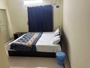 1 dormitorio con 1 cama con cortina azul en POP 84116K Hotel O Maa Tara Guest House, en Dum-Dum Junction