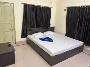 Cama grande en habitación con cortinas negras en POP 84116K Hotel O Maa Tara Guest House, en Dum-Dum Junction