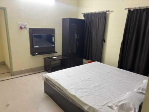 Ένα ή περισσότερα κρεβάτια σε δωμάτιο στο POP 84116K Hotel O Maa Tara Guest House