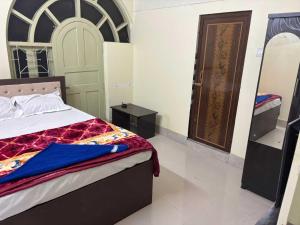 Un dormitorio con una cama y una puerta de madera. en POP 84116K Hotel O Maa Tara Guest House, en Dum-Dum Junction
