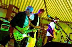 un homme jouant de la guitare sur une scène dans l'établissement Camping 3 étoiles - Piscine - eeicbi, à Le Change 177 autres photos